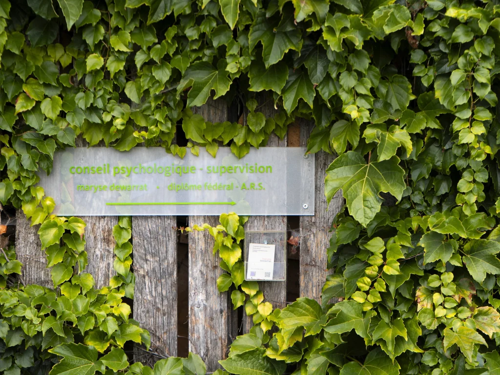 La plaque du cabinet dans le lierre, à l'entrée : l'adresse pour prendre contact sur place